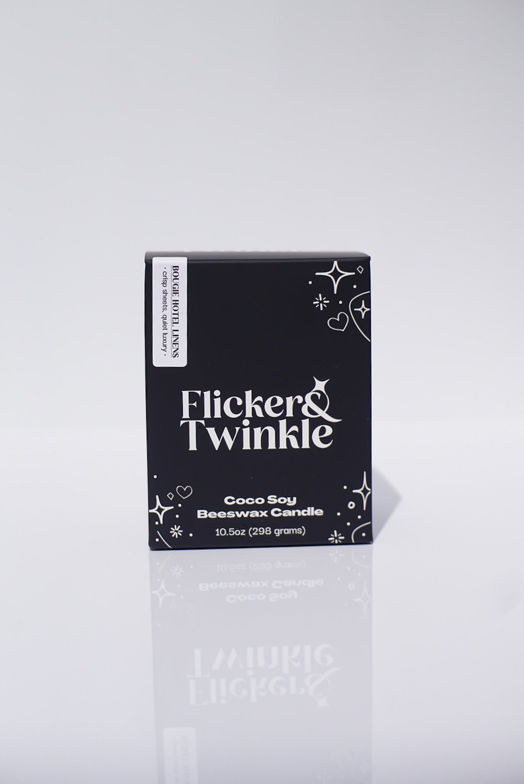 A black box labeled Bougie Hotel Linens Candle - Coconut Soy Beeswax, 10.5oz, fresh linen scent.