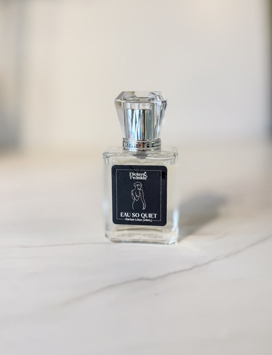 Perfume bottle labeled 'Eau So Quiet' on a light surface with a blurred background