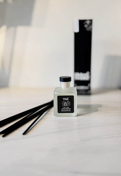 fig and pink pepper scented bottle of diffuser with sticks on a white surface