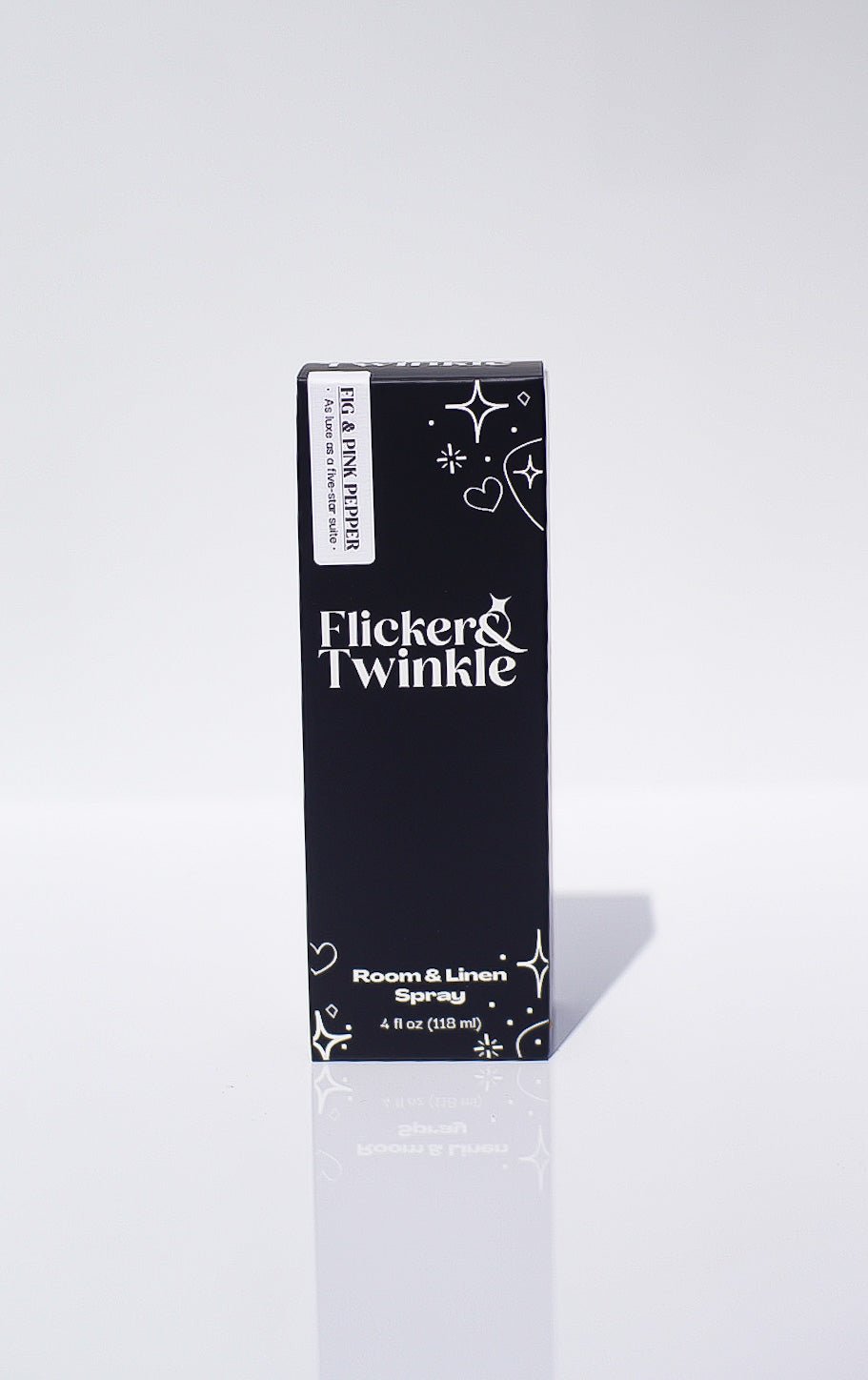 A black box with white text holds the Fig and Pink Peppercorn Room Spray, Mediterranean-inspired.