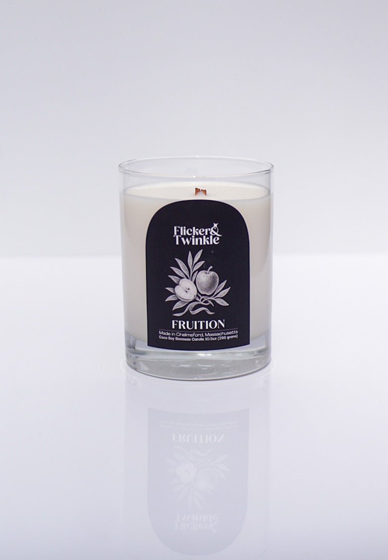 A luxury Fruition Candle – Coconut Soy Beeswax in a glass jar on a white background.