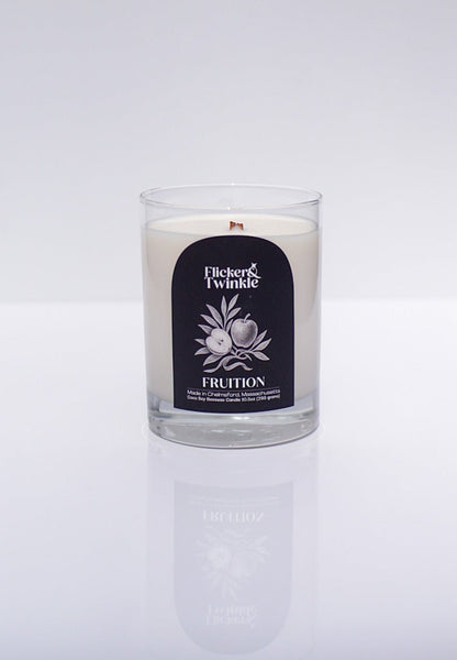 A luxury Fruition Candle – Coconut Soy Beeswax in a glass jar on a white background.
