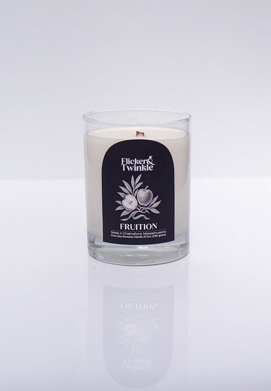 A luxury Fruition Candle – Coconut Soy Beeswax in a glass jar on a white background.