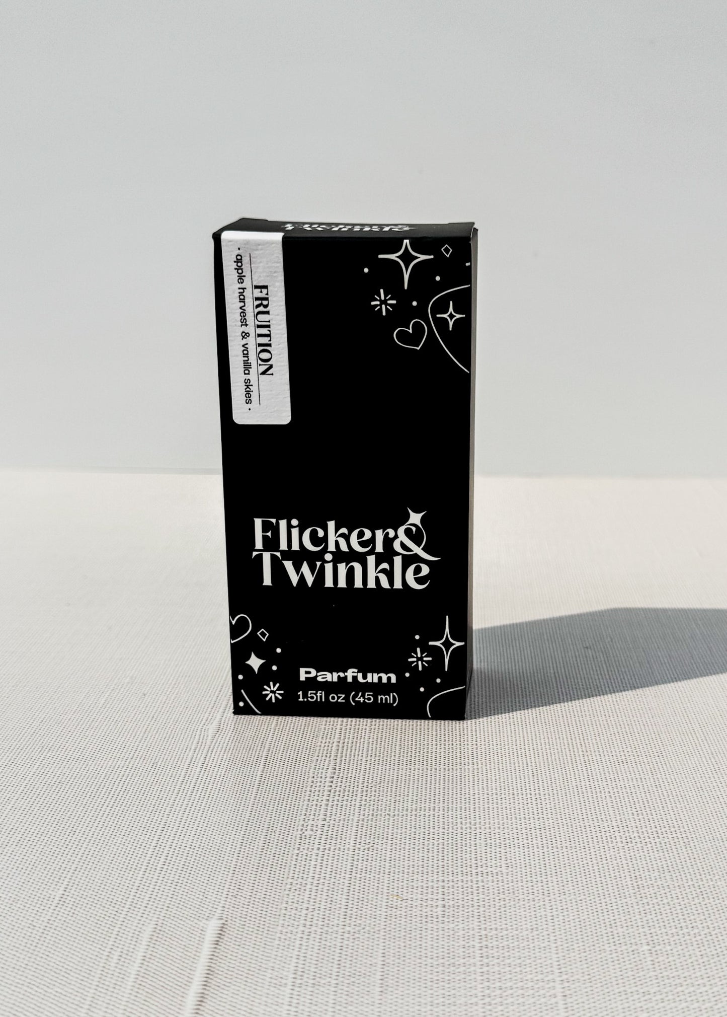 Black box of Flicker & Twinkle Parfum on a light gray background