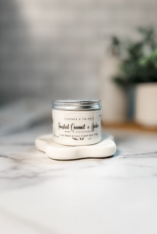Toasted Coconut and Amber Luxe Hand and Foot Cream offers deep hydration on marble surfaces.