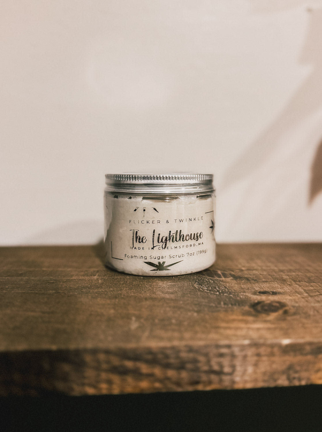 The Lighthouse Foaming Sugar Scrub on a wooden shelf