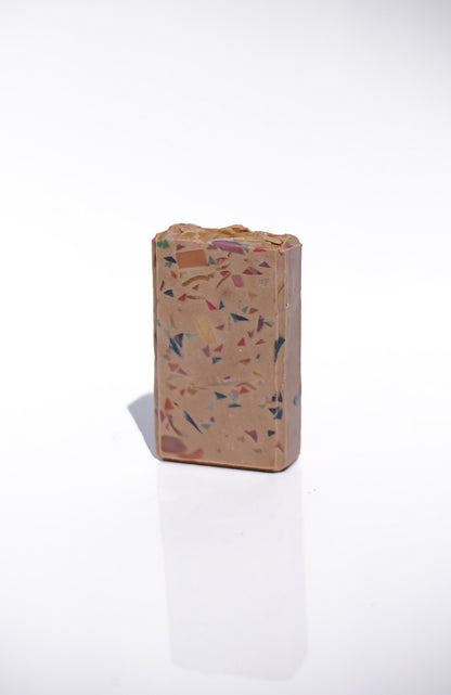 Rectangular terrazzo-style block on a white background Luxury goat milk soap—creamy lather with sandalwood & amber dry-down