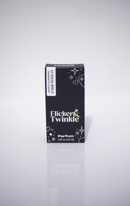 Flicker & Twinkle perfume black packaging on a light gray reflective background
