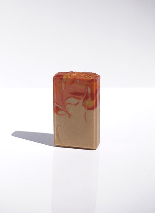 New England Goat Milk Bar of soap with bright autumn colored marbled design on top half of the bar on a white background