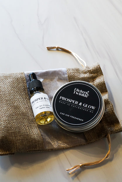 flicker and twinkle car freshener in prosper and glow bayberry holiday scent in a flat lay photo with refill 10mL bottle