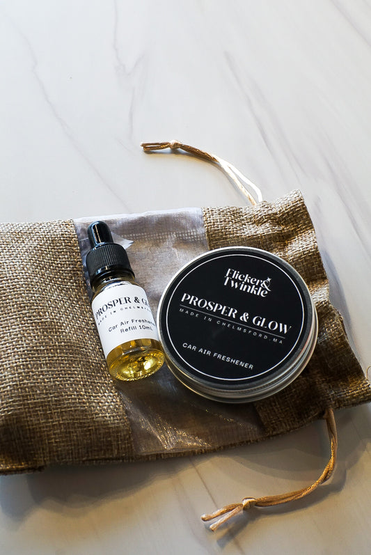 flicker and twinkle car freshener in prosper and glow bayberry holiday scent in a flat lay photo with refill 10mL bottle