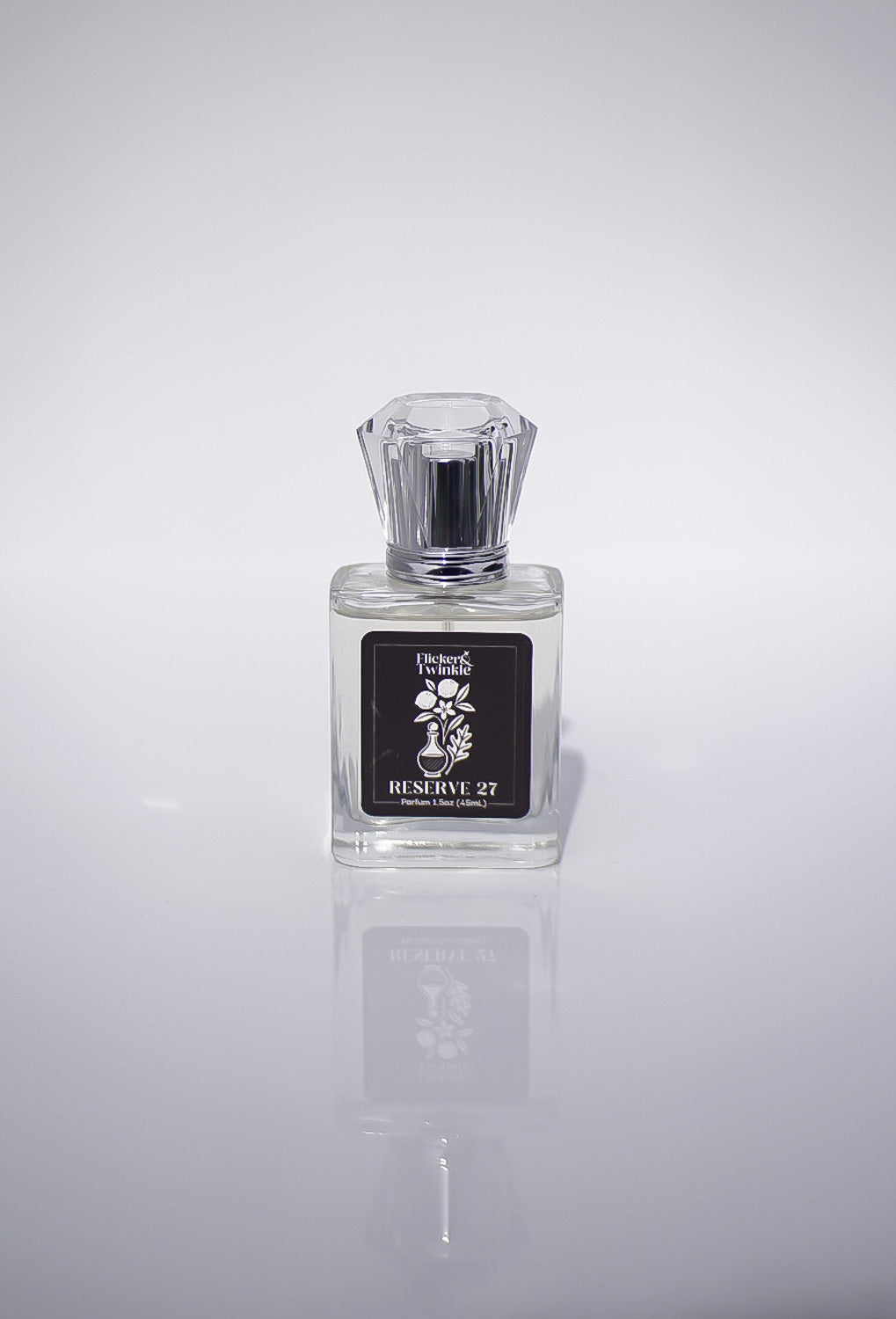Perfume bottle labeled 'Reserve 27' on a reflective gray surface with a light gray background