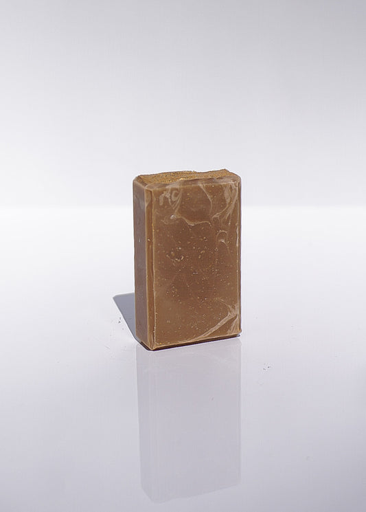 Brown rectangular bar of goat milk soap on a white background