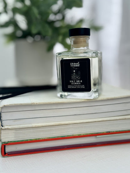 A luxury Salt Air & Echoes Reed Diffuser sits on a stack of closed books.