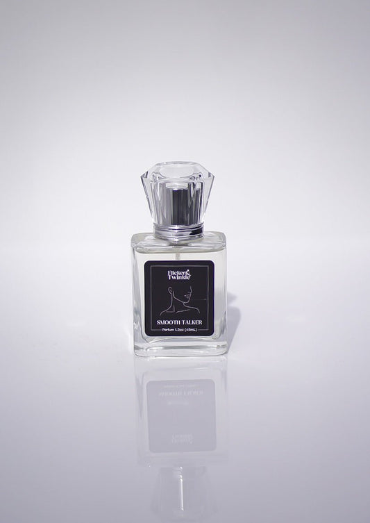 A clear glass bottle of Smooth Talker Parfum, a woody unisex scent, on a white background.
