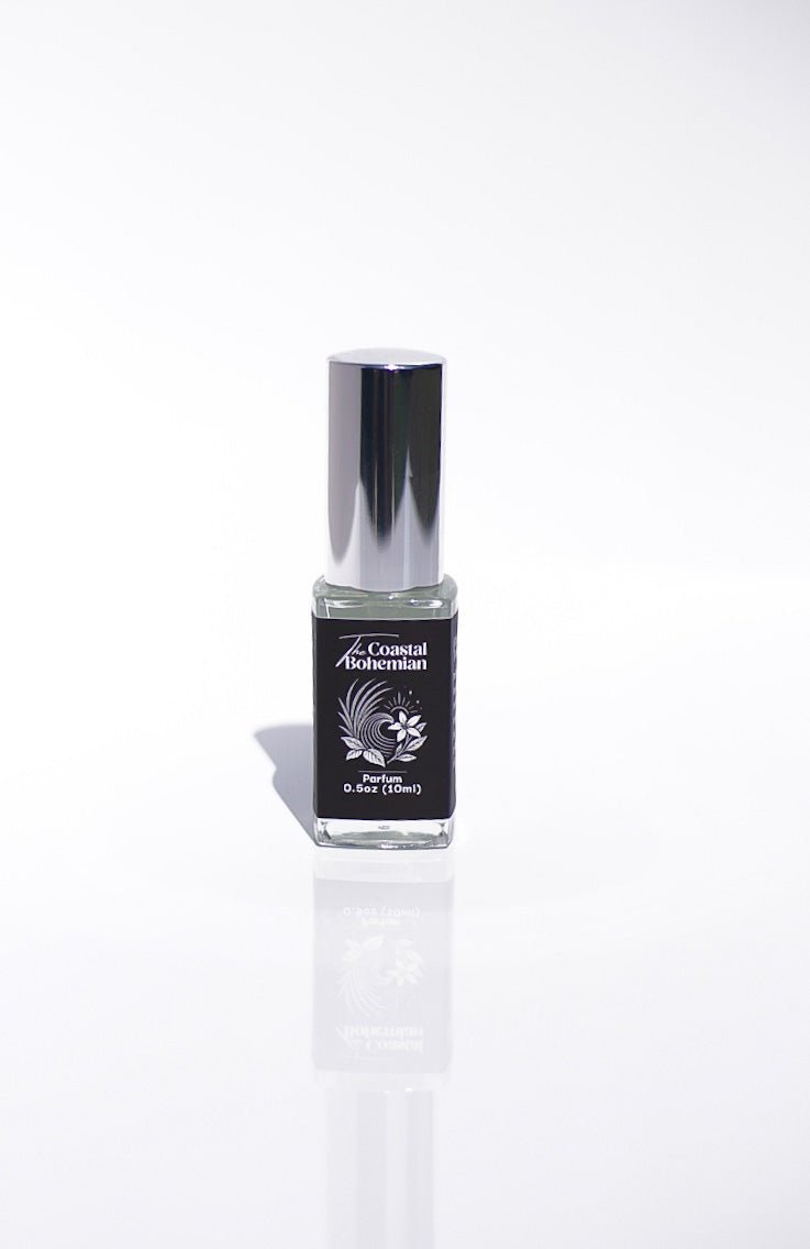 A small bottle of The Coastal Bohemian Perfume with a silver cap on a white background.