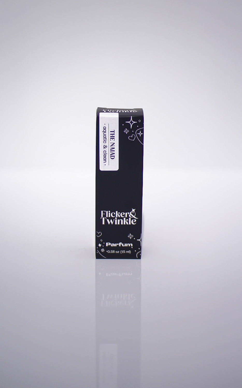 Black perfume box labeled 'Flicker & Twinkle' on a reflective gray surface