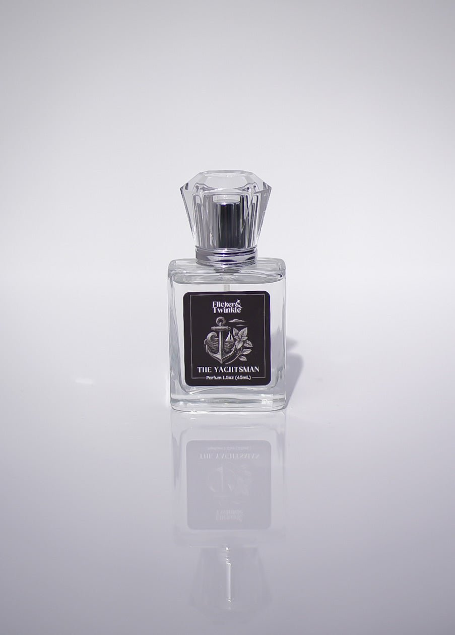 Clear glass bottle, The Yachtsman Perfume, luxury fragrance on white with soft reflection.