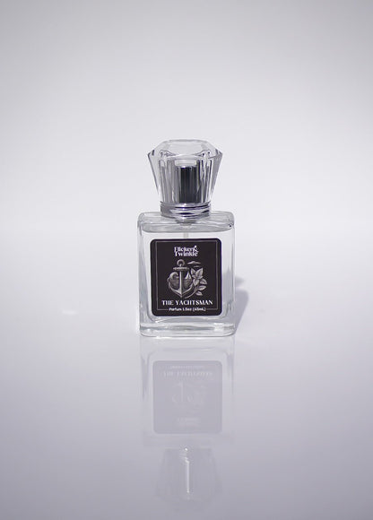 Clear glass bottle, The Yachtsman Perfume, luxury fragrance on white with soft reflection.