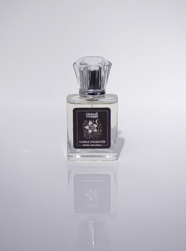 A clear glass Vanille Enchantée Perfume with a black label and faceted cap on a plain background.
