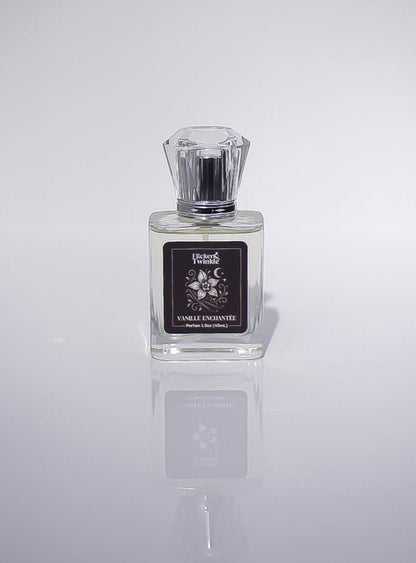 A clear glass Vanille Enchantée Perfume with a black label and faceted cap on a plain background.