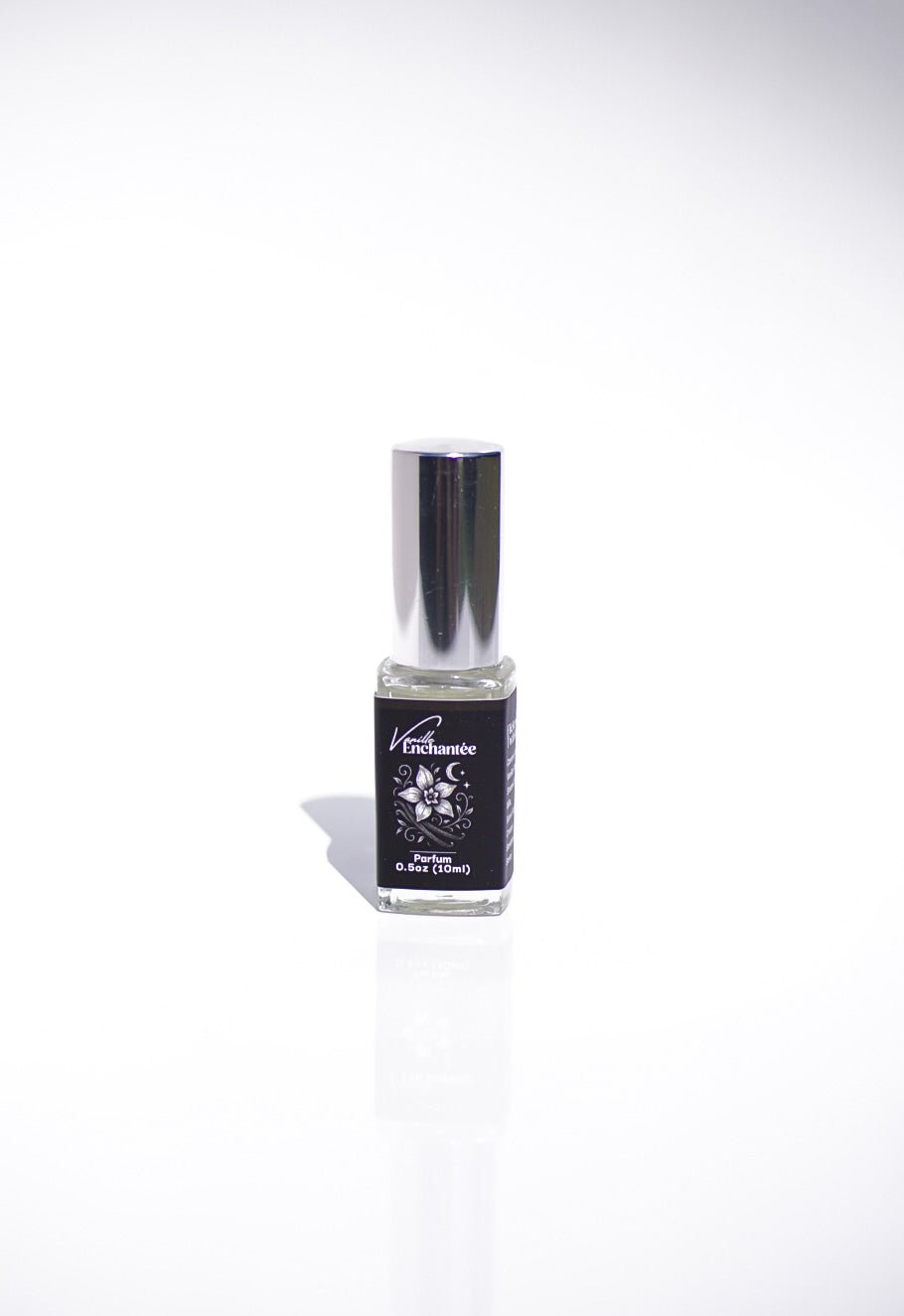 A small glass bottle of Vanille Enchantée Perfume with a silver cap on a white background.