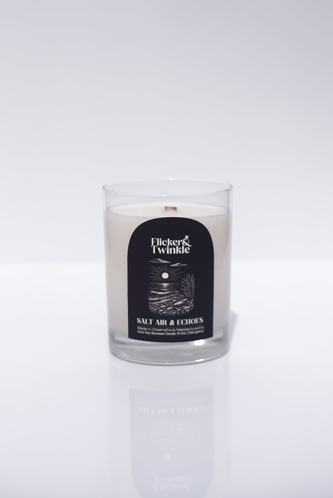 A white Salt Air & Echoes Candle in a glass jar, made with coconut soy beeswax.