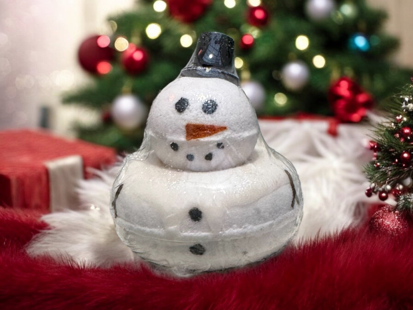 snowman bath bomb with christmas tree in the background.